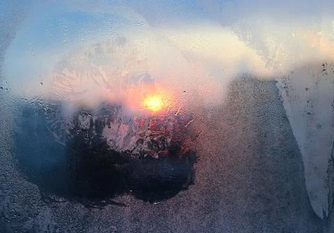 Ice pattern, water drops and sunlight on winter glass Stock Photos