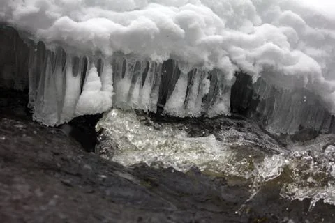 Ice patterns 4. Graceful icy fringe above water flow, Murmur water Stock Photos