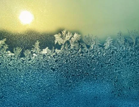Ice patterns and sun on winter glass Stock Photos