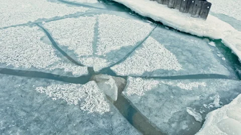 Ice patterns form on surface of frozen lake as winter arrives in a rural area Stock Footage 331326308