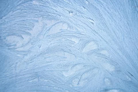 Ice patterns froze on the window. Clean blue background. beautiful texture of Stock Photos