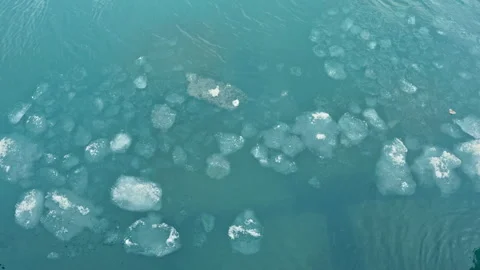 Ice pieces float calmly on clear water in a bay during summer in a location Stock Footage 331326170