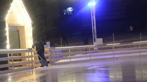 An ice rink worker is counting the remains of a snowy, icy mass from the ice Stock Footage 101303711