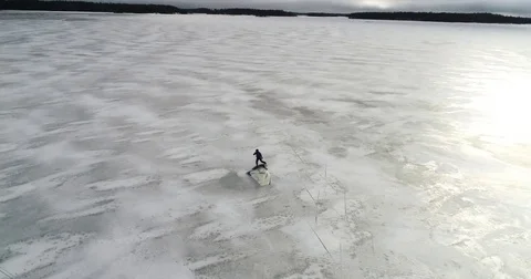 Ice sailing, Cinema 4k orbit aerial of a man fixing hes gear and starting i.. Stock Footage 73959117