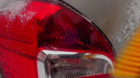 An ice scraper clears snow from a car. Medium shot. Stock Footage 296909237