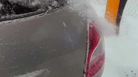 An ice scraper clears snow from a car Stock Footage 313676684