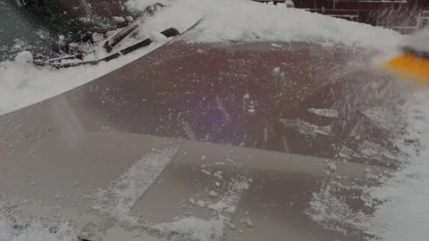 An ice scraper clears snow from a car window. Medium shot. 库存影片 314678660