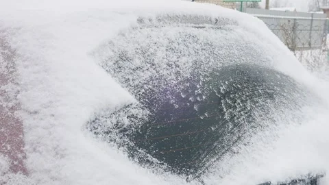 An ice scraper clears snow from the surface of a car. Medium shot. Stock Footage 296909186