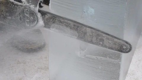 Ice sculptor trims an ice block with a chain saw 4K Видео 101447027