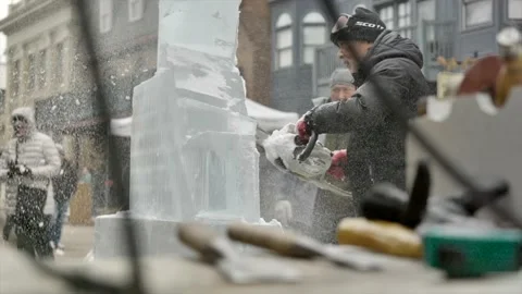 Ice sculptor using chainsaw, blur sculpting tools on foreground. Static, Stock Footage 143379495