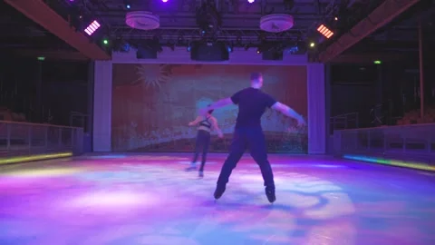 Ice skaters couple performs spin rotation figure elements on snow arena Stock Footage 137466669