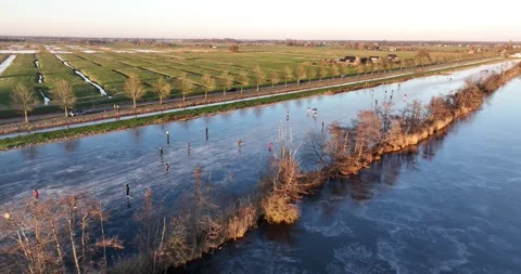 Ice skating on the canals in Holland. Winter day sunset and people on the ice Stock Footage 261994953