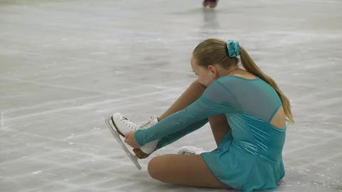 Ice skating coach helping young girl with ice skating injury 動画素材 88173569