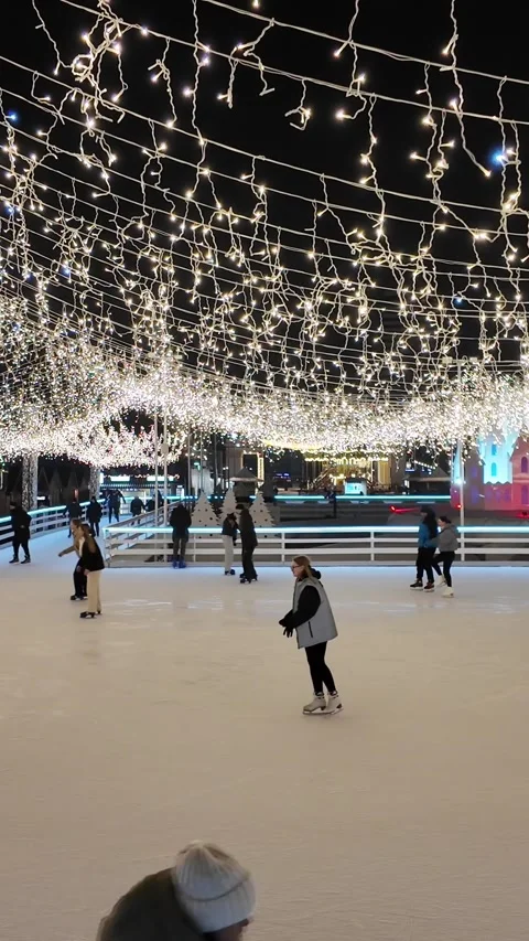 Ice Skating Under Festive Lights at Night Stock Footage 305459203
