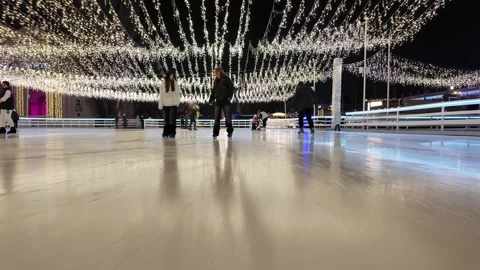 Ice skating under glowing festive garlands at night 스톡 동영상 309531443