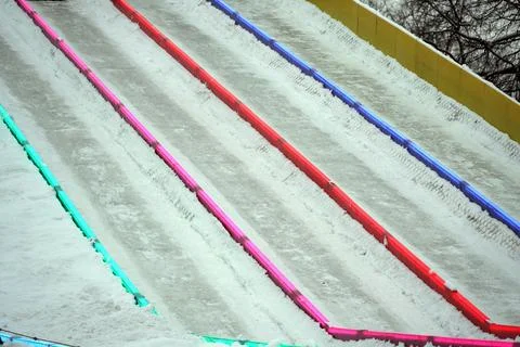 Ice slide for skiing with separation of tracks by luminous multi-colored rail Stock Photos