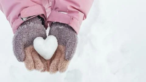 Ice small snow heart in open children's palm on light blue background copyspace Stock Photos