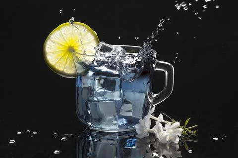 Ice splashing into a refreshing drink. Stock Photos