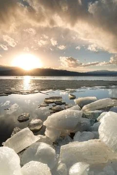 Ice stacks in vertical image at Vineyard Beach on Utah Lake in Utah at suns.. Stock Photos