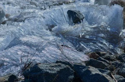 Ice structure of river hummocks in spring. River bank with stones and ice fra Stock Photos