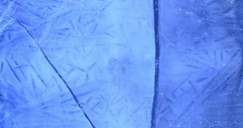 Ice surface shows detailed lines and patterns that reflect light in a blue hue Stock Photos