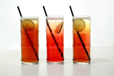 Ice tea with lime slice and straw served in glass isolated on grey backgrou.. Stock Photos
