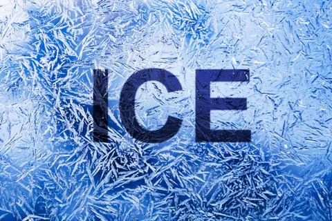 Ice text on frozen patterned glass.on winter window Stock Photos