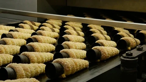 Ice waffle cones baked move over the conveyor belt in a bakery factory Stock Footage 75930259