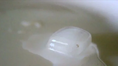 Ice, a watch, a lighter, and hands captured in macro 库存影片 333706426