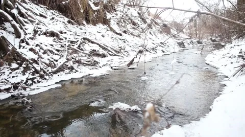 Ice water running in a fast spring stream. Snow melting on steep creek banks Stock Footage 47526278