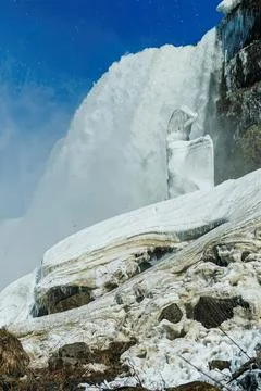 Ice waterfall flowing down mountain in cold winter scene Stock Photos