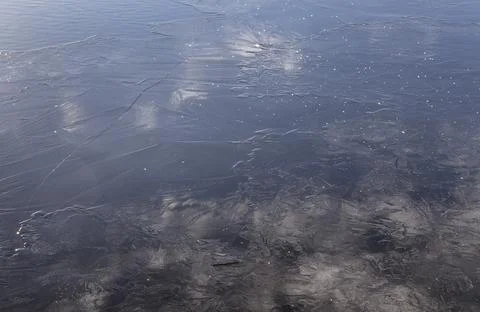 Ice on a winter river with a reflection of clouds Stock Photos
