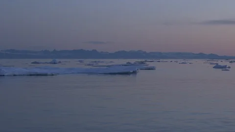 Iceberg on the Arctic Ocean with mountain in the background, Greenland Video stock 102511004