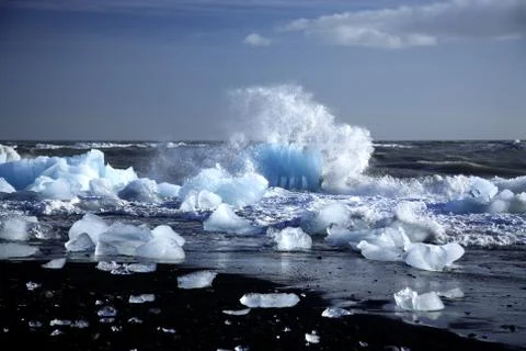 An iceberg being broken by the waves Stock Photos