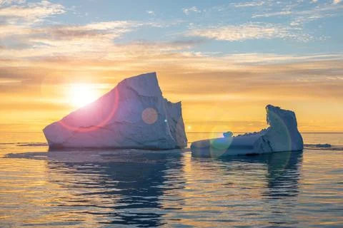 Iceberg extraordinary form at sunset in backlight rays of the sun in Antarcti Stock Photos
