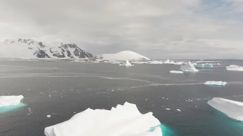 Iceberg floating in the Arctic ocean with massive ice shelf in the horizon Stock Footage 290160258