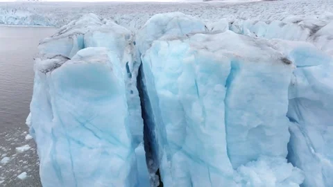 Iceberg floating in the Arctic ocean with massive ice shelf in the horizon Stock-Footage 297533340