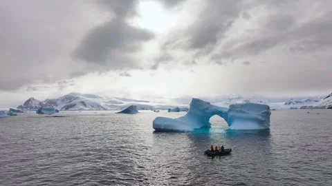 Iceberg floating in the Arctic ocean with massive ice shelf in the horizon 库存影片 303647958