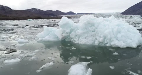 Iceberg with glacier and kayakers on Svalbard in the high Arctic Stock Footage