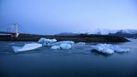 Iceberg parts float to the ocean under a bridge in the bay in the famous Jo.. Stock Footage 260916548