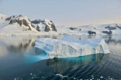 Iceberg reflection, calm blue ice water, soft evening light, glacier, Antarctica Stock Photos