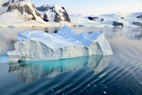Iceberg reflection, calm blue ice water, soft evening light, glacier, Antarctica Stock Photos