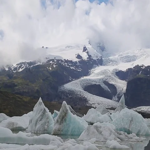 Icebergs and glaciers with reflection of clouds on lake lagoon Stock Footage 69404031