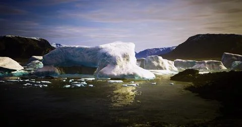 Icebergs float gently in a tranquil bay under a clear sky at sunset Stock Illustration