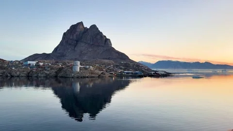 Icebergs float near a mountain at dawn in a quiet Arctic landscape Stock Footage 339998655