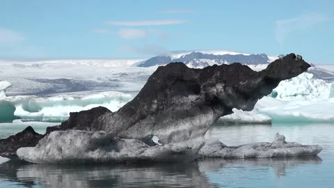 Icebergs float peacefully in a tranquil lagoon under clear blue skies in Iceland 库存影片 321590355