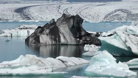 Icebergs float peacefully in a tranquil lagoon under clear blue skies in Iceland 库存影片 321590357