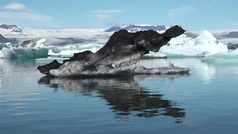 Icebergs float peacefully in a tranquil lagoon under clear blue skies in Iceland 库存影片 321590359