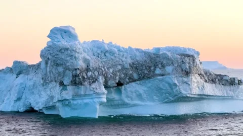 Icebergs float peacefully in a tranquil lagoon under clear blue skies in Iceland 库存影片 321590385
