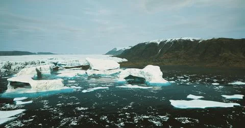 Icebergs float in serene waters with mountain backdrop during daylight Stock Illustration